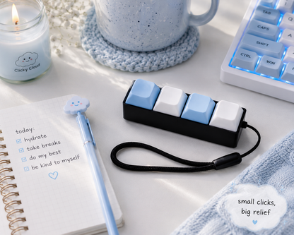 Small device with blue and white keys on a desk with a notebook, pen, and candle.