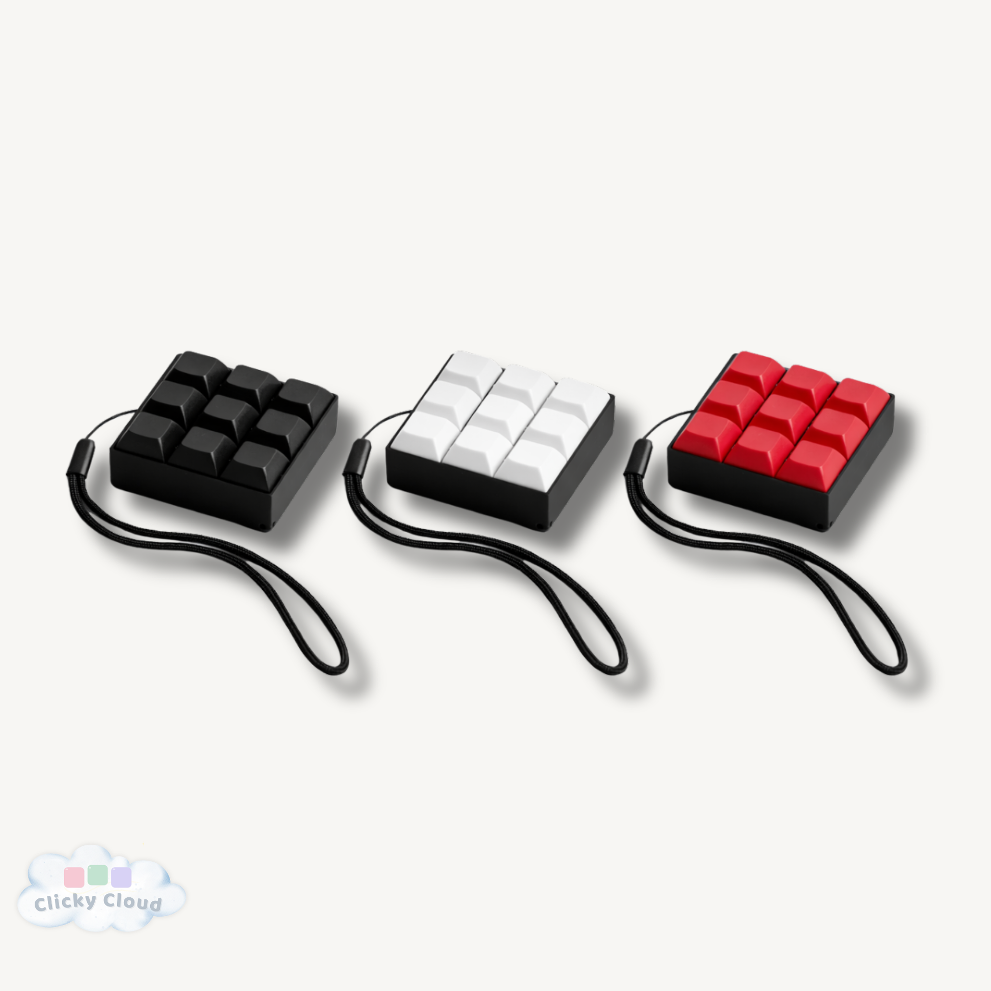 Three keychain keyboard fidget clickers with black, white, and red buttons on a white background.