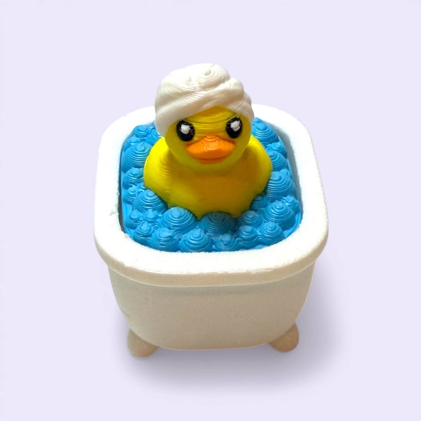 Yellow rubber duck clicker in a bathtub filled with blue water on a white background