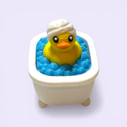 Yellow rubber duck clicker in a bathtub filled with blue water on a white background