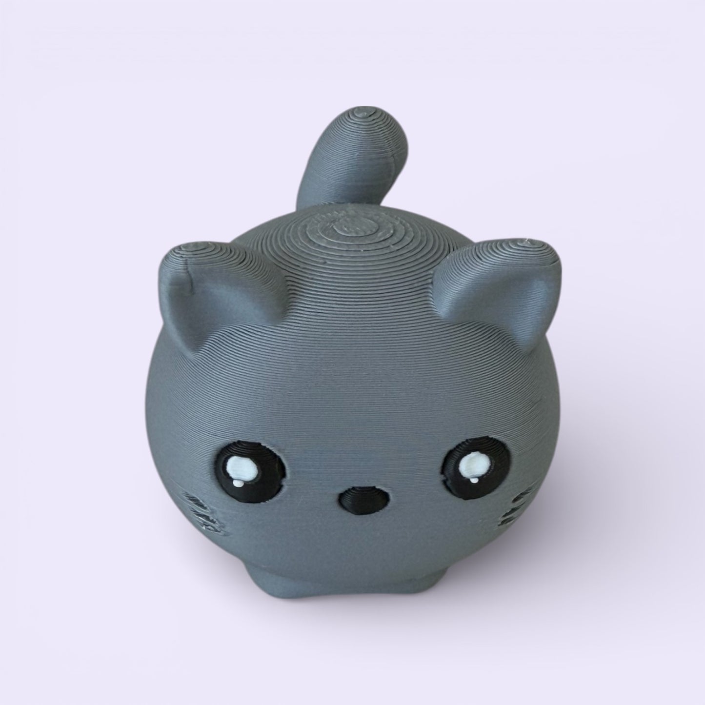 Gray cat-shaped object on a light purple background