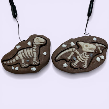 Two dinosaur skeleton clickers on a white background