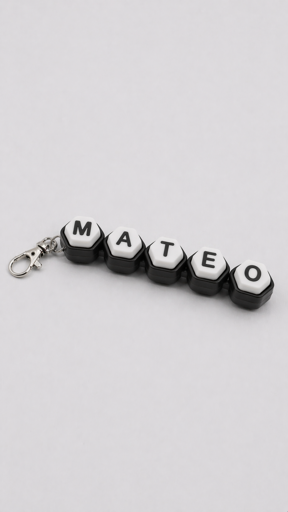 Keychain with letter beads spelling 'MATEO' on a light gray background