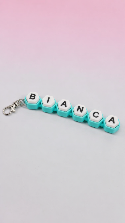 Keychain with letter tiles spelling 'BIANCA' against a gradient background