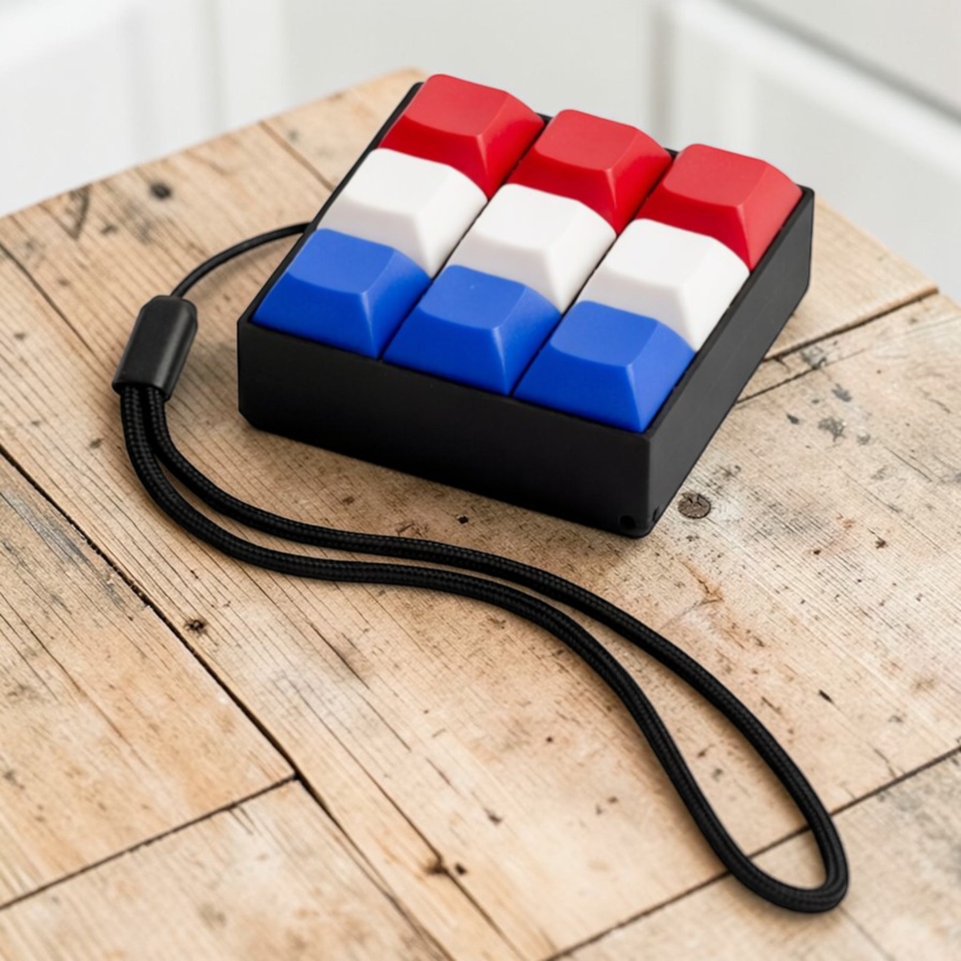 Keychain with red, white, and blue keys on a wooden surface
